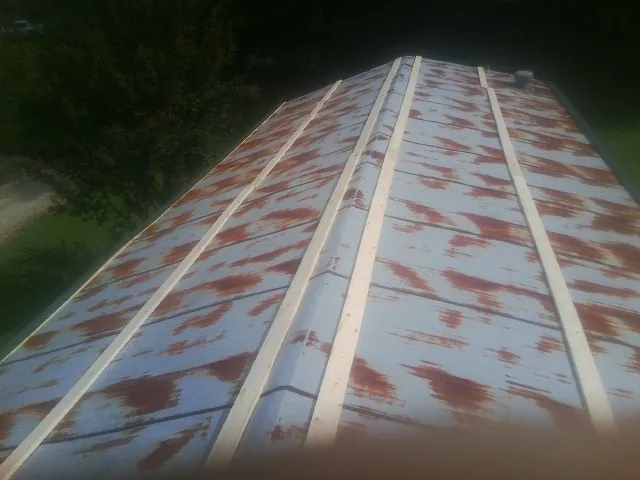 Rusted metal roof panels with new wood purlins before replacement — Storm Damage Roof Repair in Asher by Roofing Brothers
