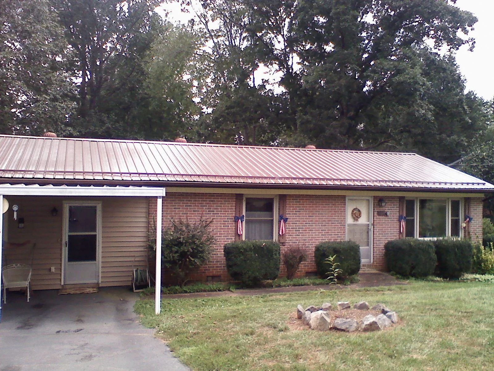 Bronze metal roof and carport on a brick ranch home — Roof Repair work by our crew in Asher