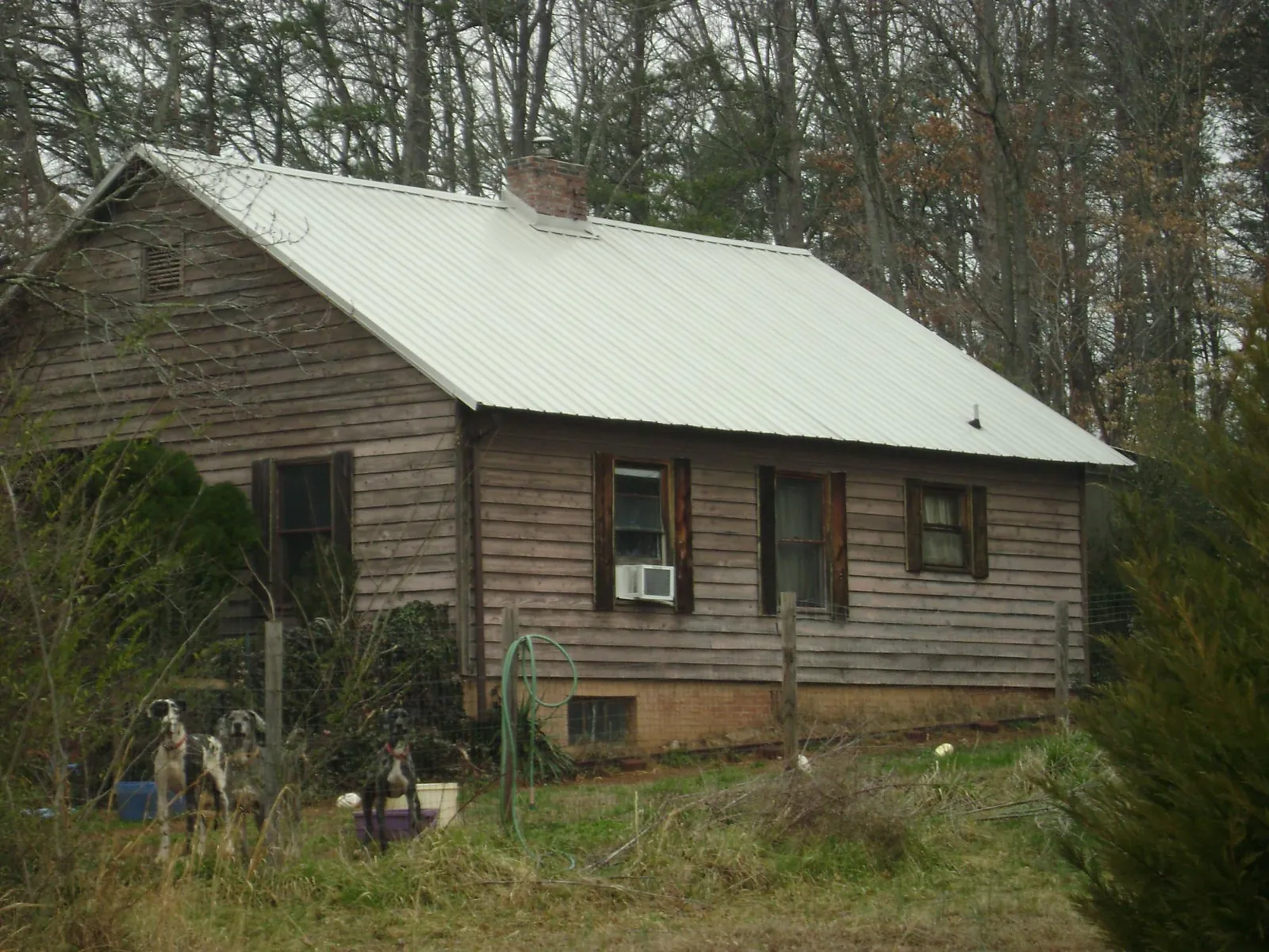 White metal roof on an old wood sided farmhouse, from a Metal Roof Installation job in Asher